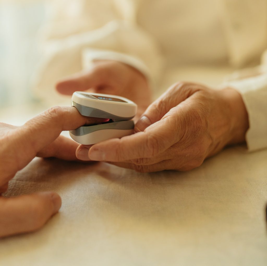 Closeup of hands using a pulse oximeter
