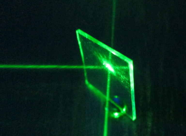 A green laser beam being split by an aluminum coated beamsplitter