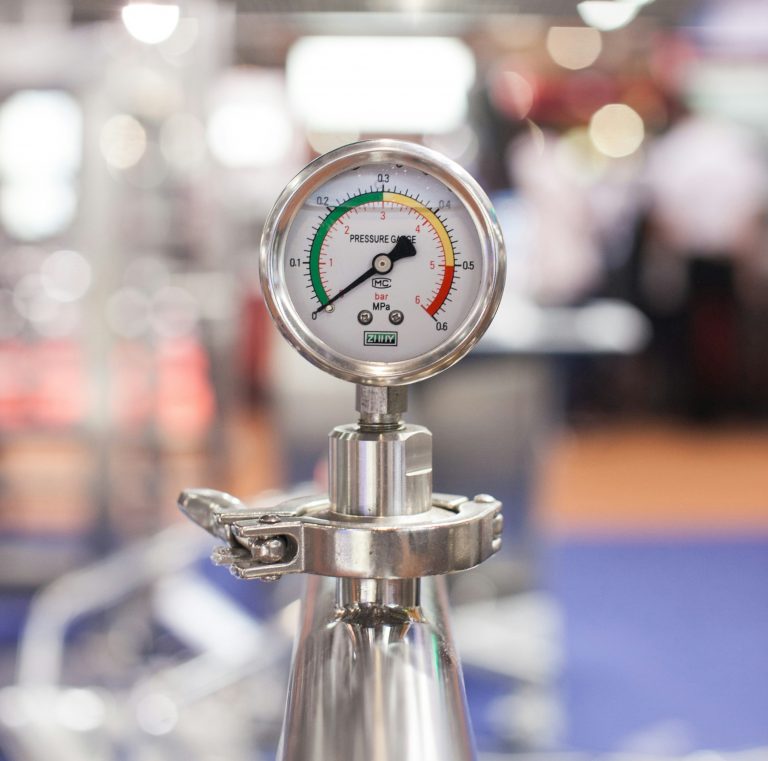 Closeup of silver pressure gauge in laboratory